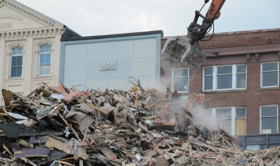 A large equipment arm hanging over scraps of a destroyed building from a Perth demolition project performed by Focus Demolition
