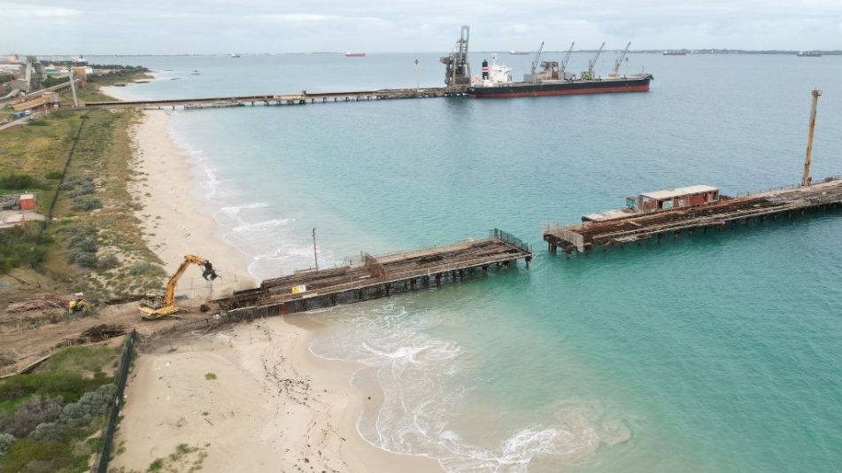 Far wide shot of the Kwinana Jetty Demolition showing the length of the jetty and heavy machinery ready for demolition.